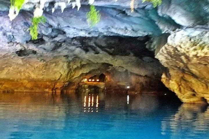 Blick aus dem Inneren einer Höhle hinaus zum Eingang, der sich im ruhigen Wasser spiegelt